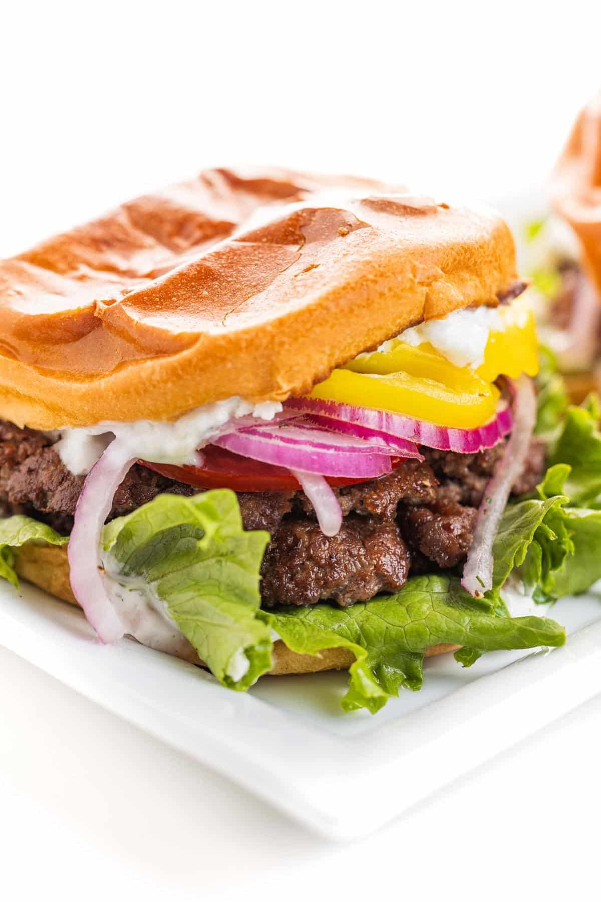 Greek smash burger assembled on a plate.