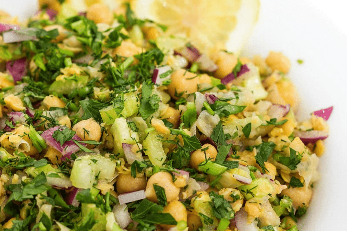 Smashed chickpea salad with fresh lemon slices.