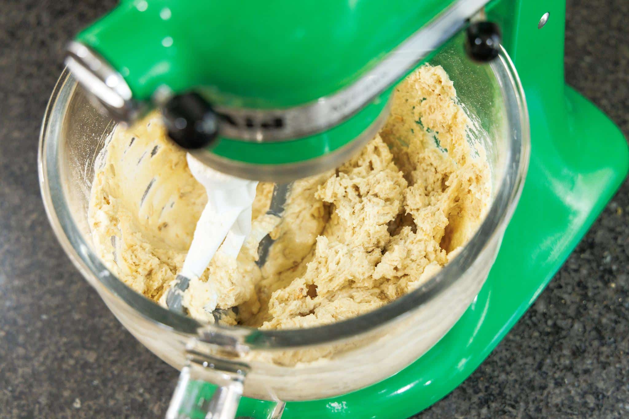 Mixing dry ingredients into the wet ingredients.
