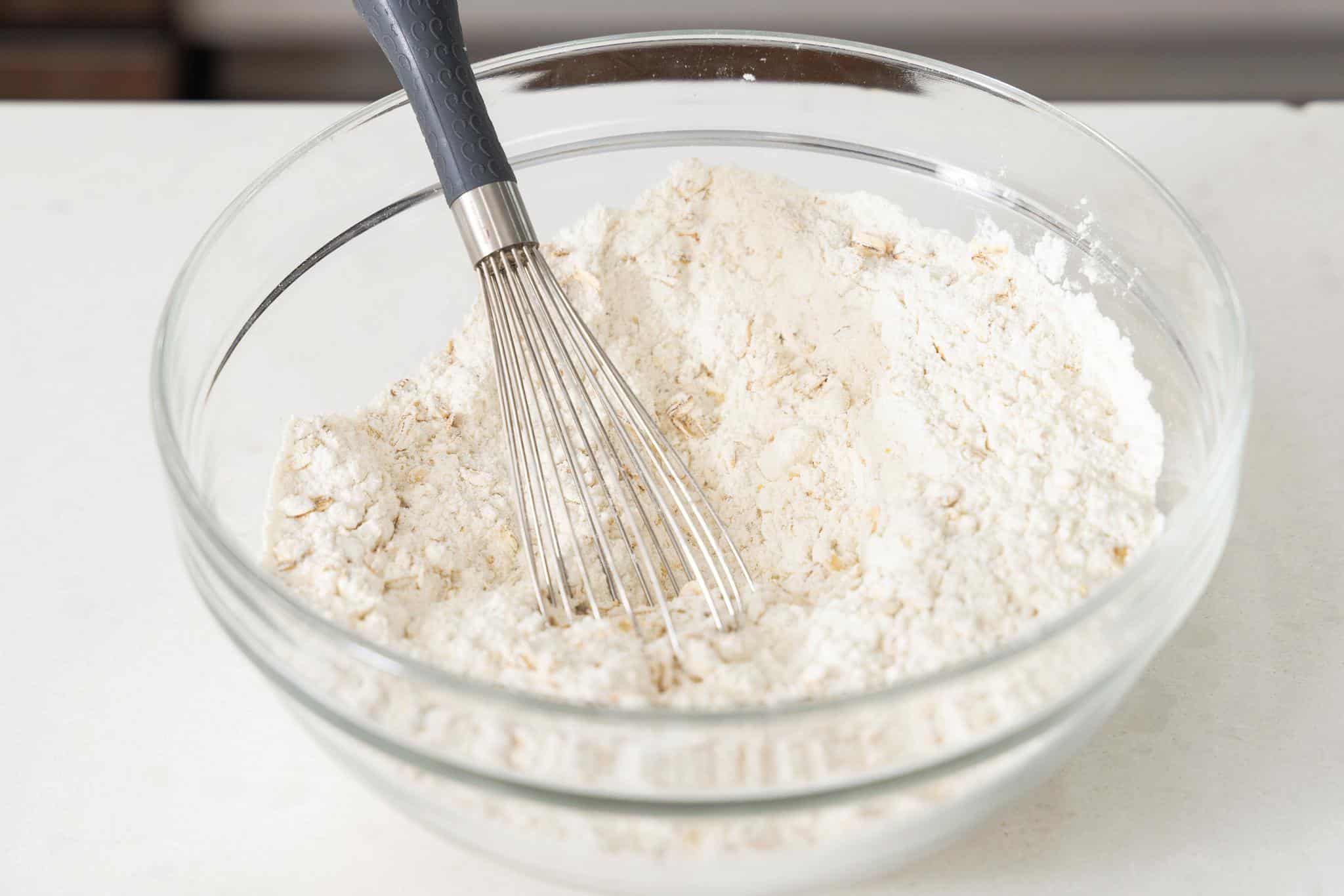 Whisking together dry ingredients in a large glass bowl.