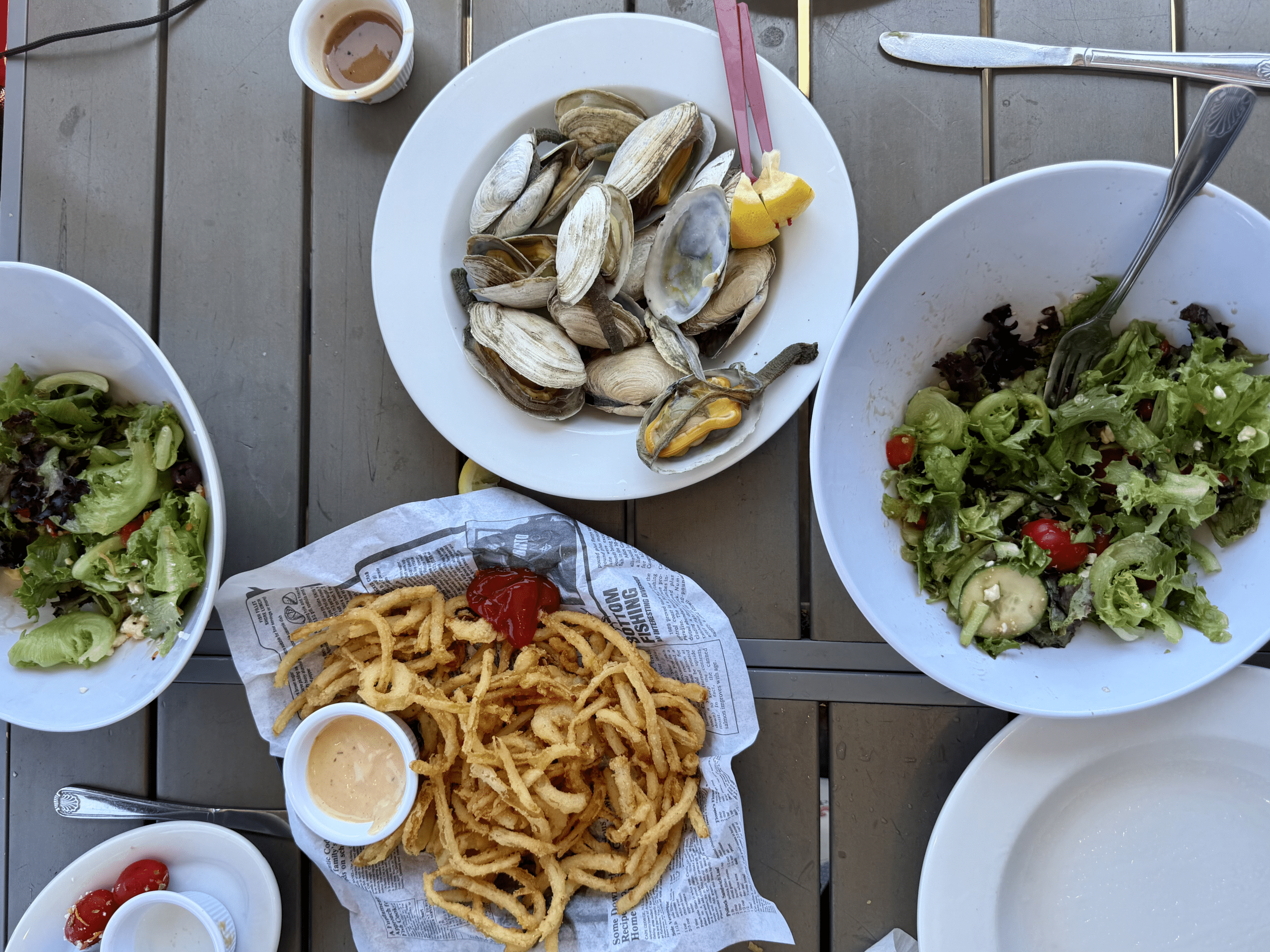 Salad, mussels, and fries on the harbor.